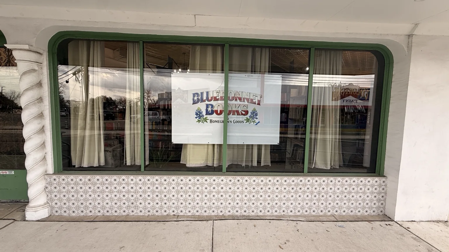 Front window view featuring the Bluebonnet Books & Homegrown Goods sign.